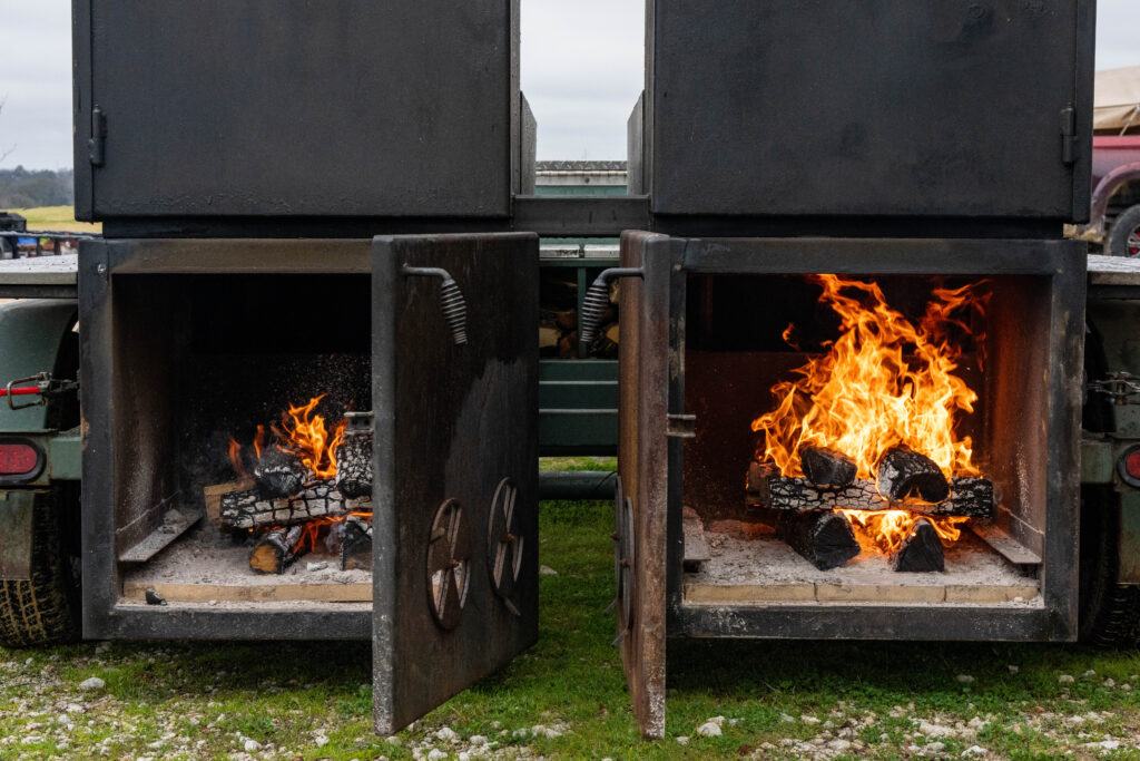 a photo of two large smokers with their doors open to show the fire inside