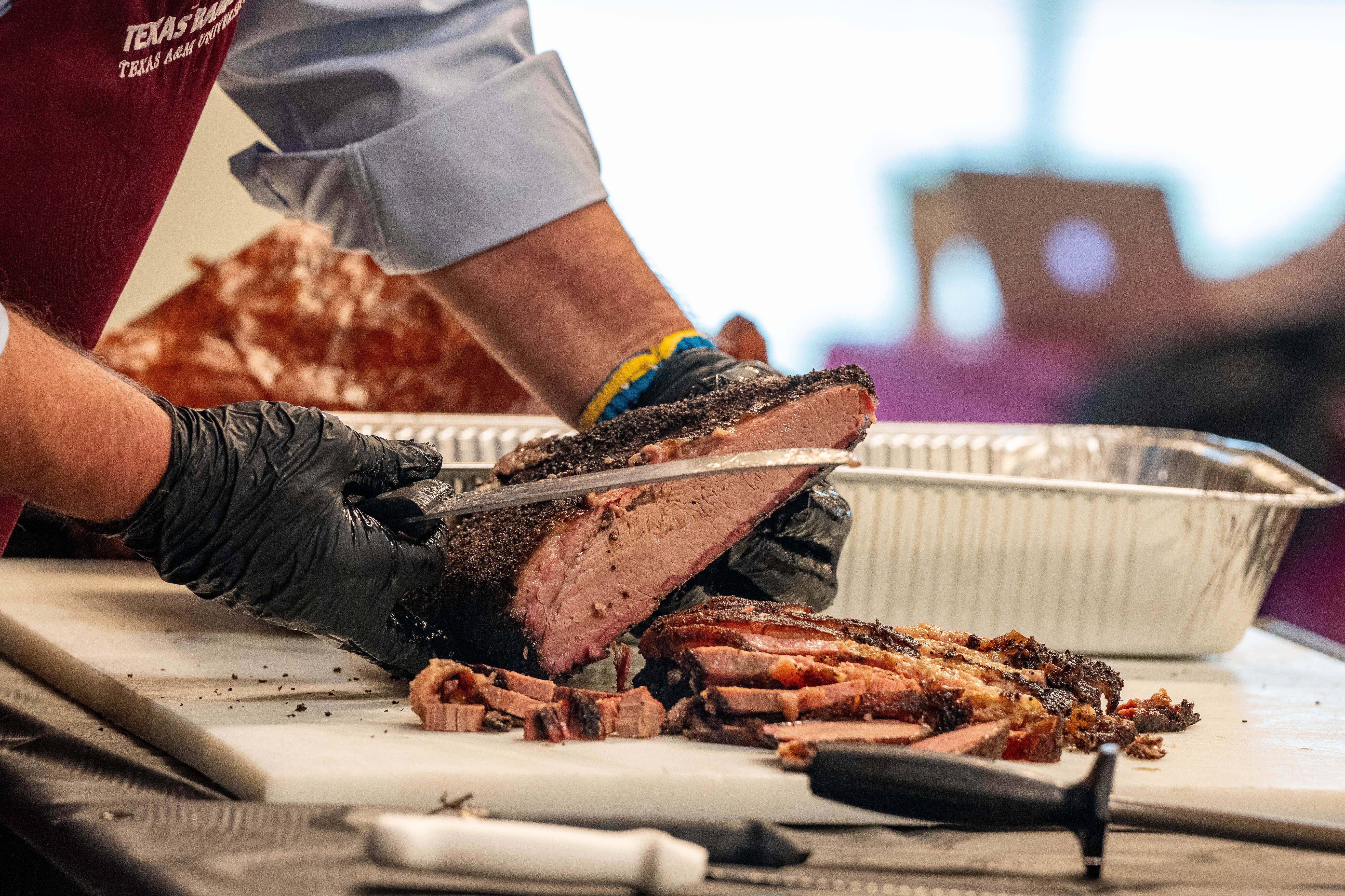 a photo of a smoked brisket being carved on a large cutting board