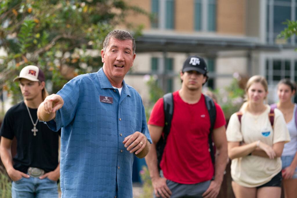 Johnson leading a tour of The Gardens with students in the background