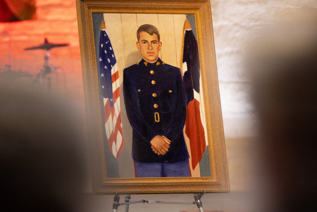 A photo of a painting of a U.S. Marine Corps veteran on display during a memorial service.