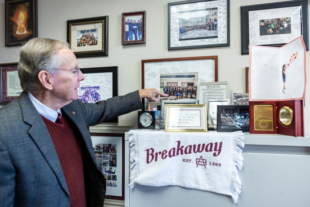 McDaniel looks through framed photos and momentos displayed in his office