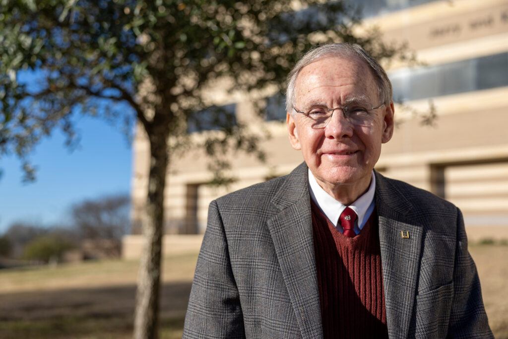 Dr. Stephen McDaniel standing outside his office with a tree in the background