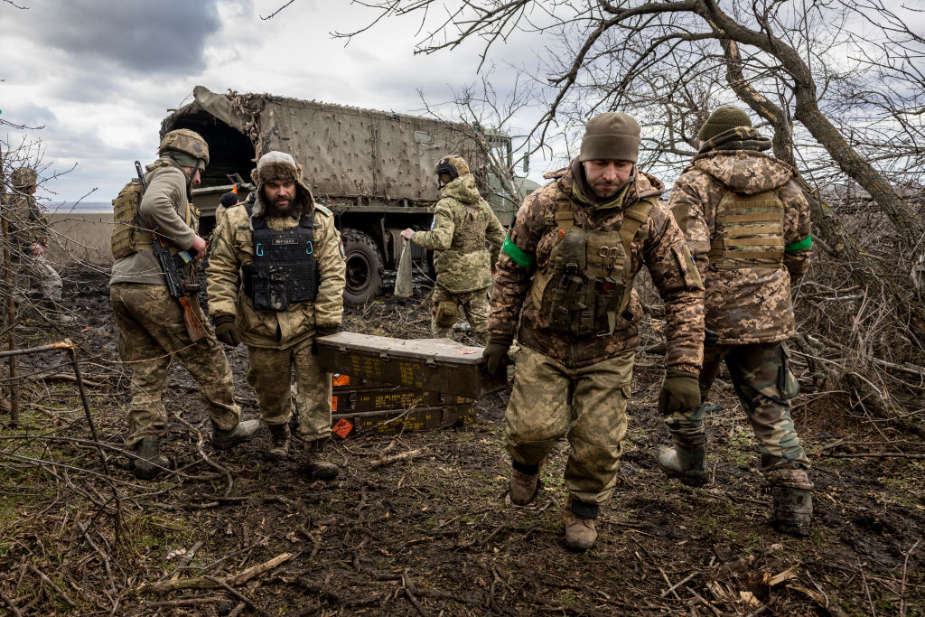 a photo of men in military uniforms unloading boxes of munitions from a truck in Ukraine