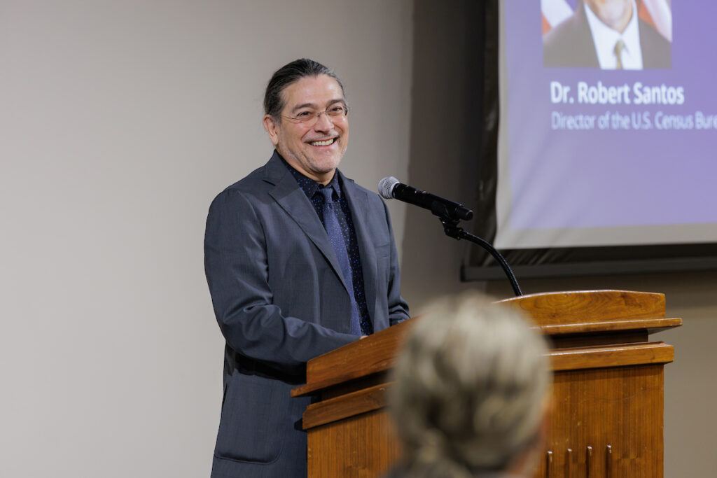 U.S. Census Director Robert Santos standing at the podium during his presentation at Texas A&M University