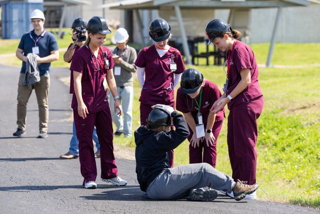 A photo of students tending to someone with an injury during a mass disaster training exercise.