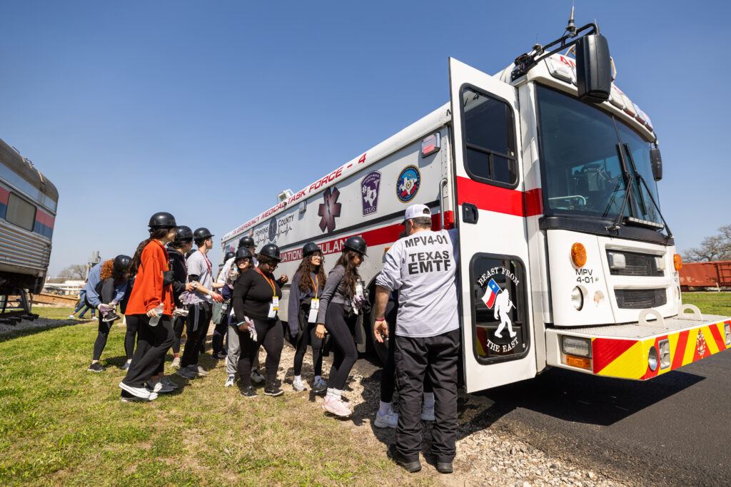 A photo of students about to board a large ambulance during a mass disaster training exercise.