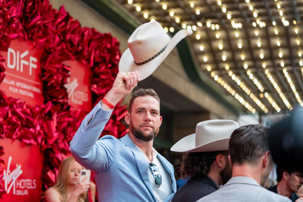 Cody Jones tips his cowboy hat to the crowd on the red carpet