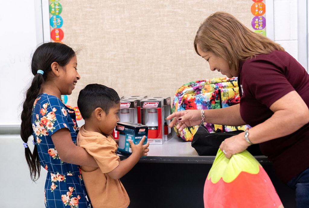 two young children laughing with a fair volunteer