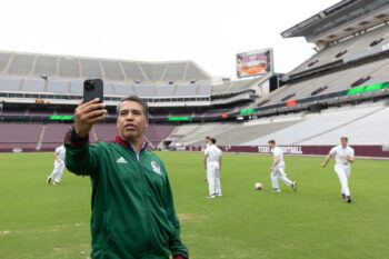 Pavel Pardo takes a selfie while the Yell Leaders kick a soccer ball on Kyle Field