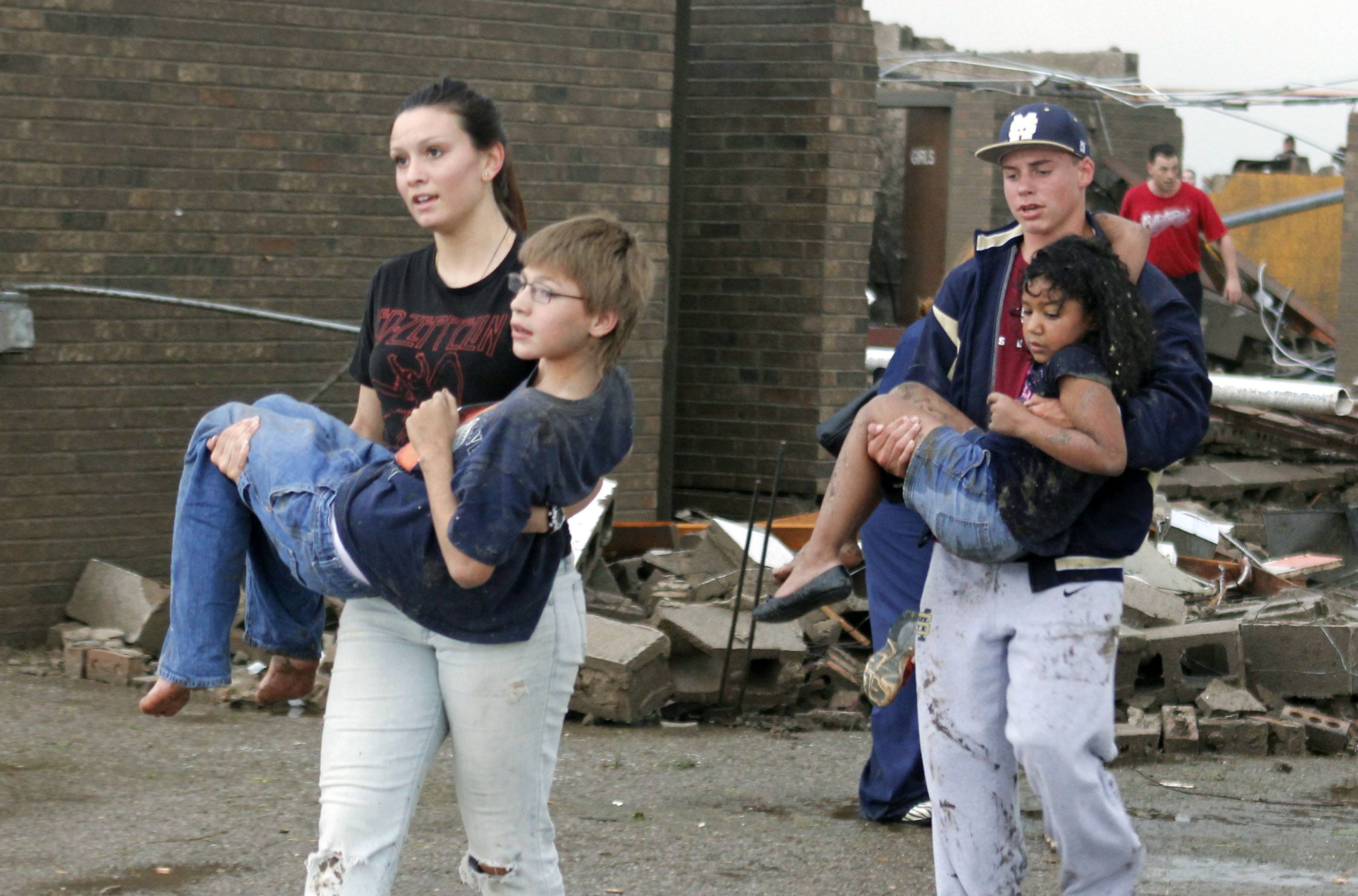 Vargyas (right), being carried away from what remains of Briarwood Elementary School, which was completely destroyed by the EF5 tornado that swept through Moore, Oklahoma, on May 20, 2013.