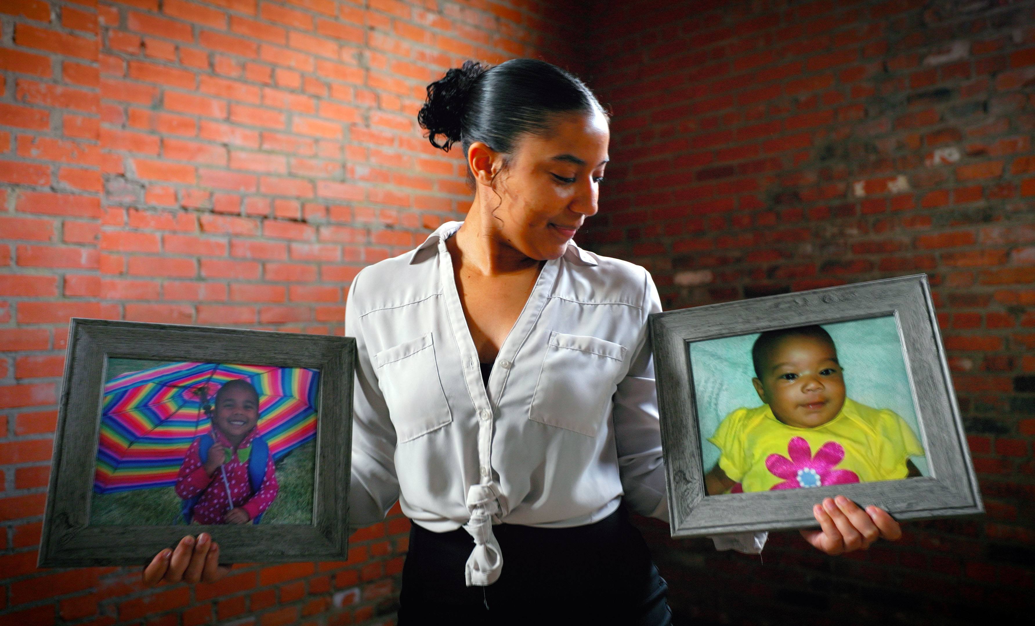 Vargyas, holding framed photographs of her younger sisters and career inspirations Karrina (left) and Sydnee (right), who were among the 24 fatalities in the 2013 Moore tornado.