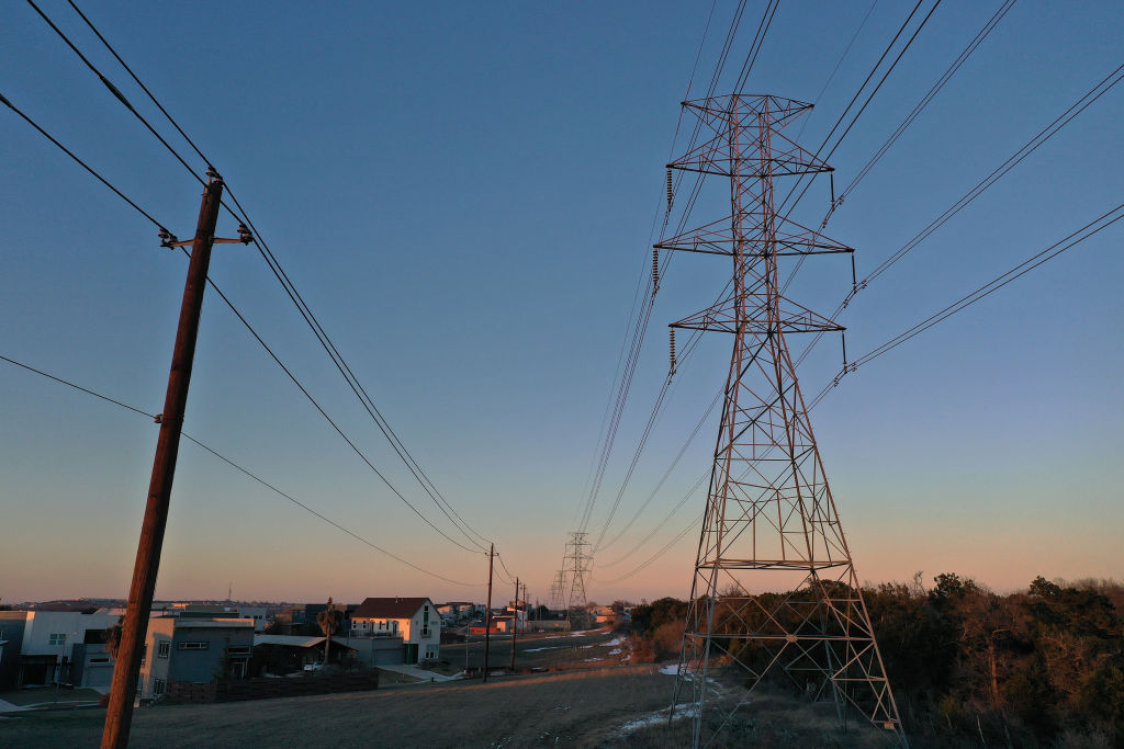An aerial view of power lines running through a neighborhood at sunset.