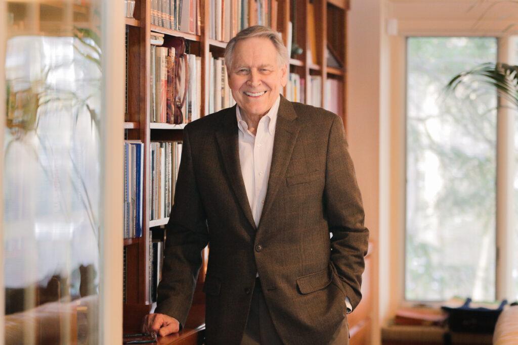 Portrait of Jon Hagler standing in front of a bookcase