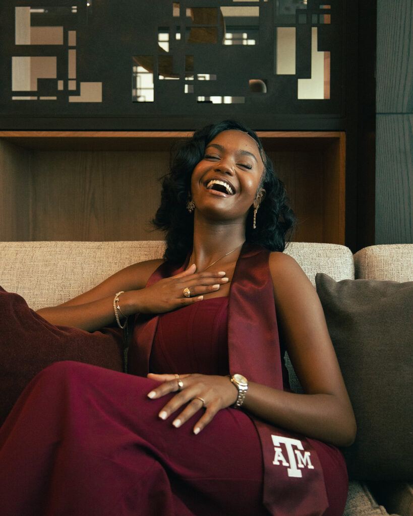 a photo of a young woman smiling in a maroon dress and Texas A&M graduation stole