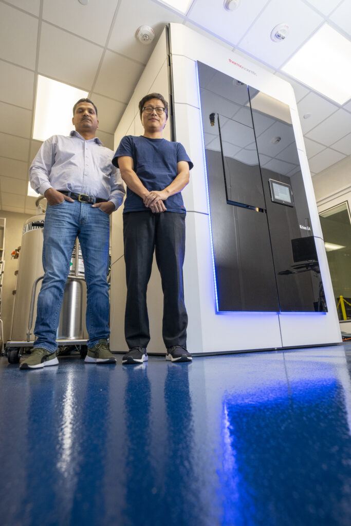 Two men standing outside of the cryogenic electronic microscope
