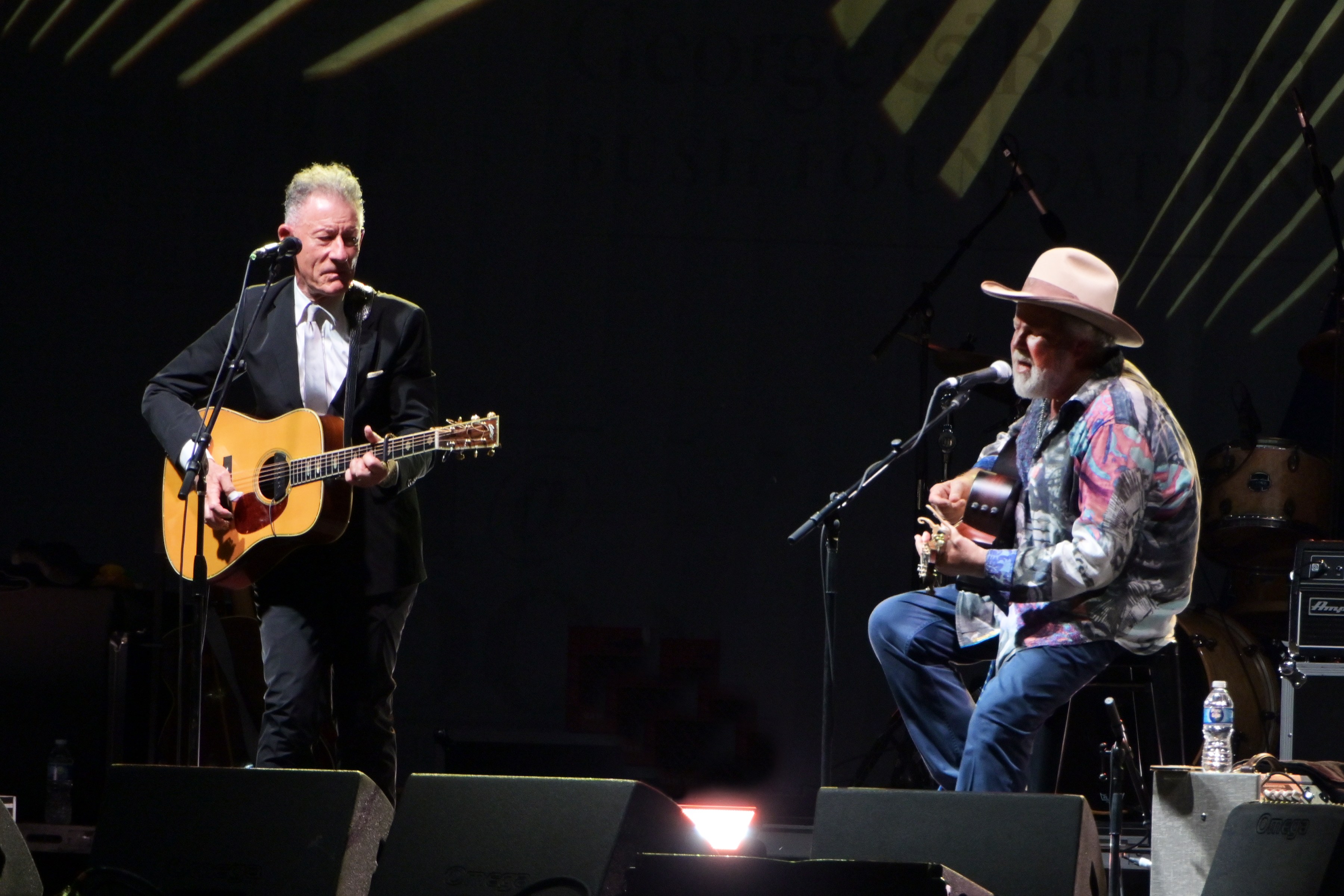Musicians Lyle Lovett and Robert Earl Keen perform on stage.