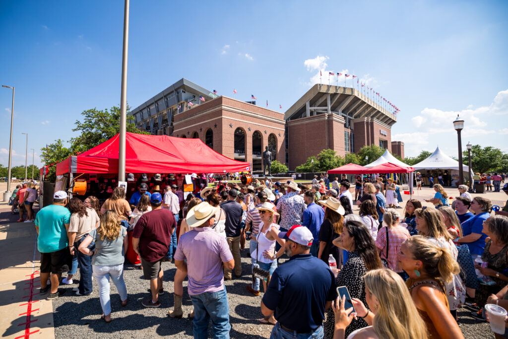 Fans gather outside merchandise tents at Kyle Field prior to a George Strait concert.
