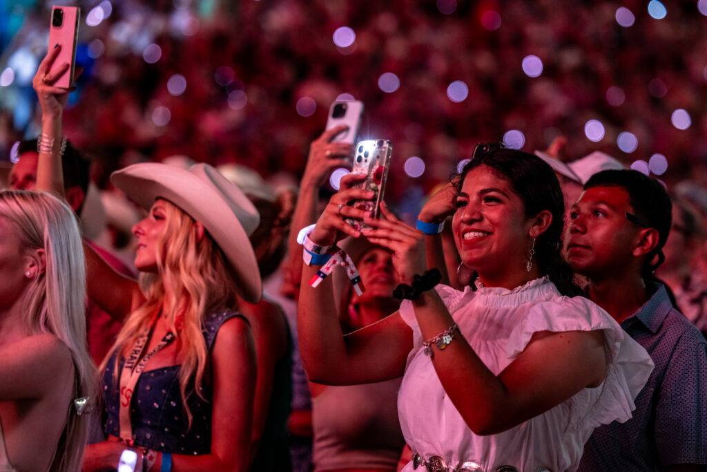 Fans take photos at a George Strait concert in Kyle Field.