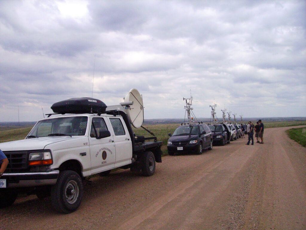 A photo of storm-chasing vehicle along a dirt road on a cloudy day.