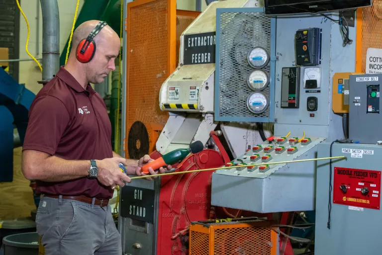 Adam Pickens, PhD, tests equipment at a cotton gin