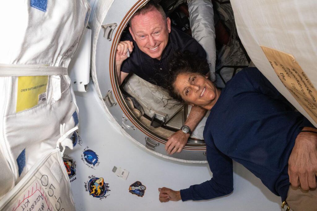 Two astronauts pose for a portrait inside the International Space Station