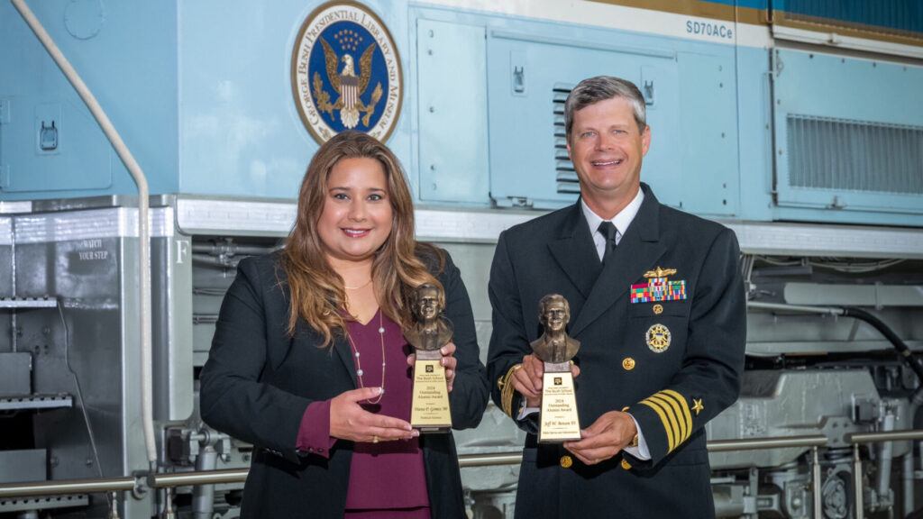 A photo of two award winners standing with their awards.