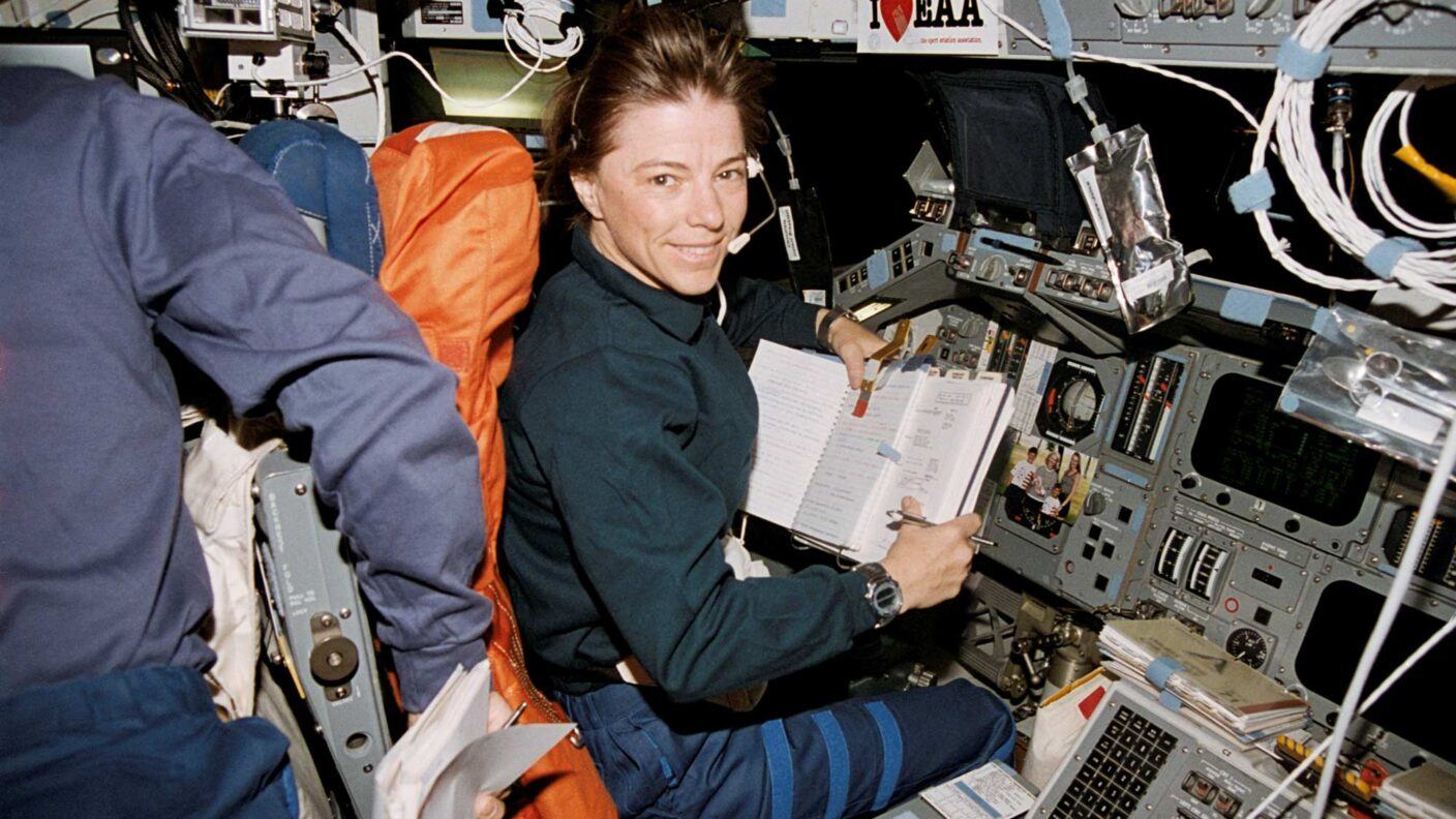 A photo of an astronaut at the controls of a space shuttle.