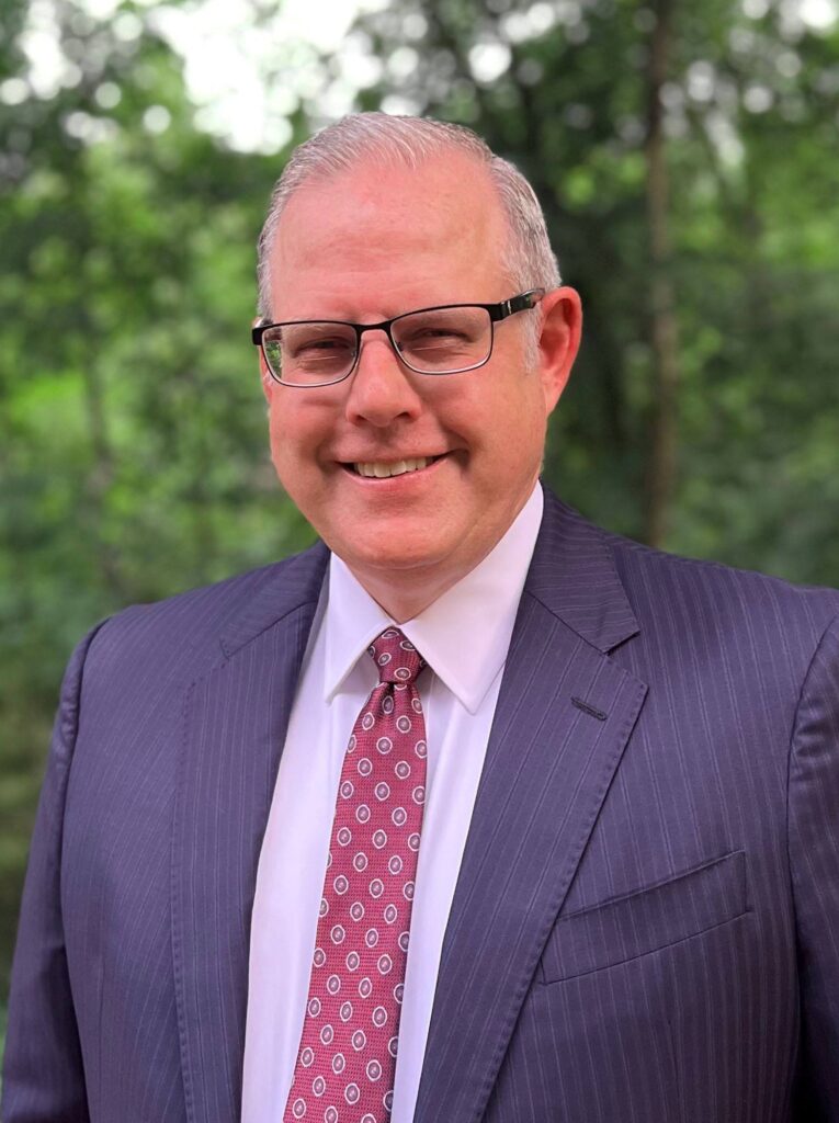A portrait of John B. Sherman standing outside.