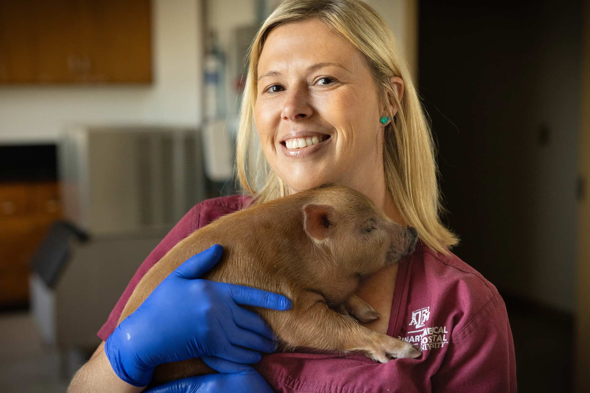 A photo of Dr. Jennifer Fridley holding a piglet.