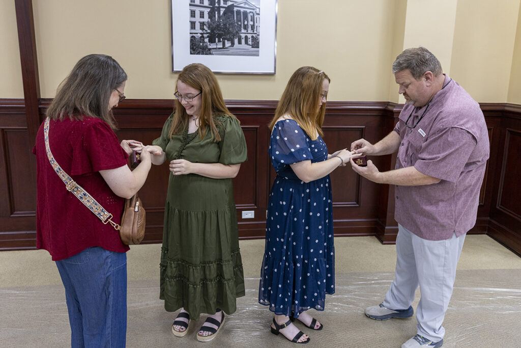 The twins receiving their Aggie rings from their parents, who are both Aggies.