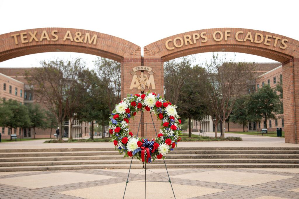 A photo of a wreath placed at the entrance to the arches of The Quad at Texas A&M University.