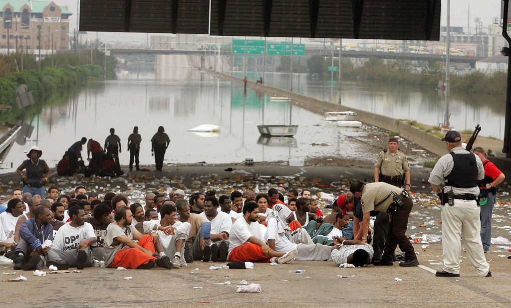NEW ORLEANS - SEPTEMBER 01: Police watch over prisoners from Orleans Parish Prison who were evacuated from their prison to the highway due to high water September 1, 2005 in New Orleans, Louisiana. Rescue efforts continue as officials in New Orleans fear the death toll from Hurricane Katrina could be in the thousands.