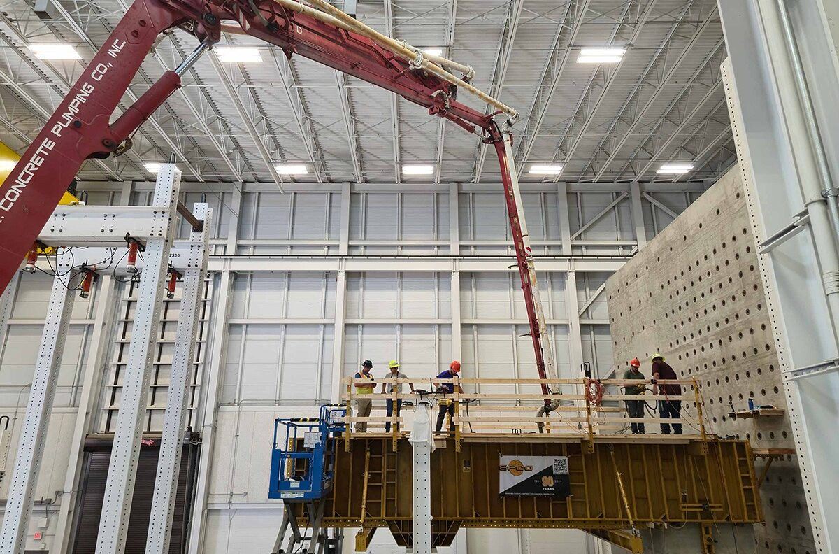Researchers replicate a construction sequence using a concrete pump truck and structural formwork to cast the straddle bent at full scale.
