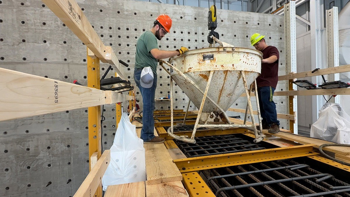 Researchers begin pouring concrete into the framework of a full-scale straddle bent bridge beam.
