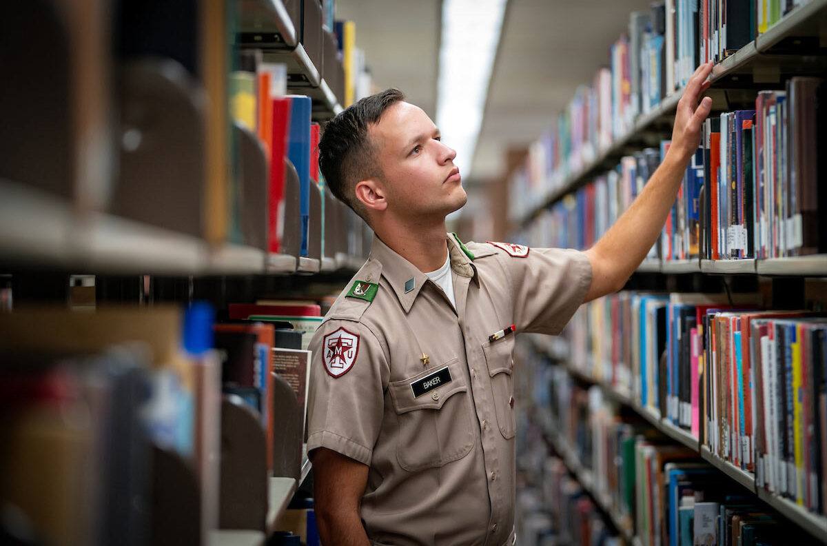 History major Jackson Baker '25 looking through library shelves