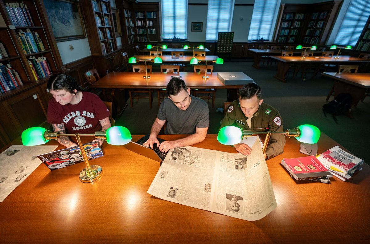Jackson Baker and two other history interns cross-reference historic newspapers with online databases