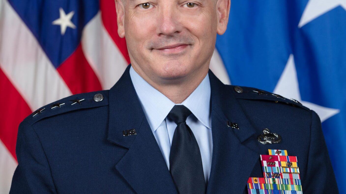 A portrait of U.S. Air Force Lt. Gen. Michael Downs in his dress uniform in front of a U.S. flag.