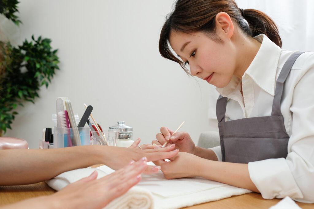 Nail stylist working on someone's fingernails.