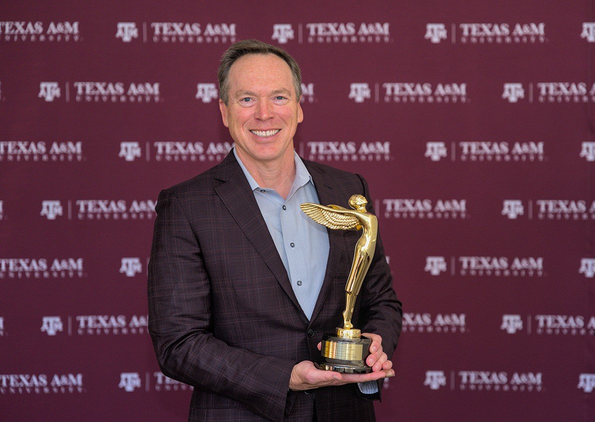 A photo of a man holding a trophy.