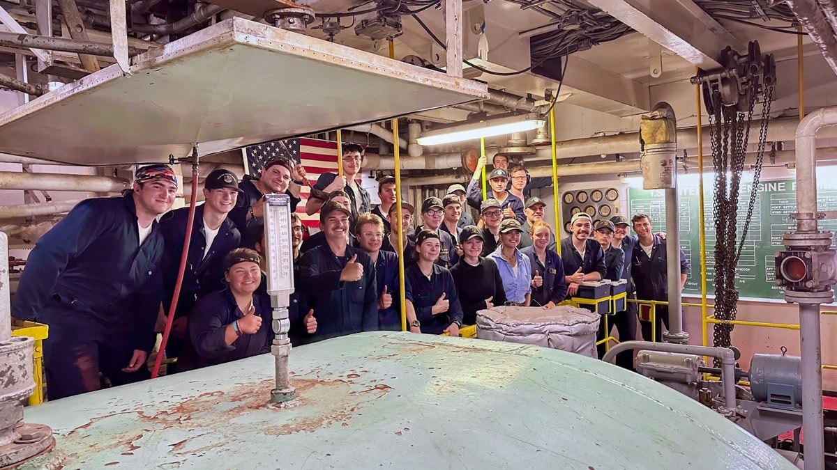 Group of students in a ship's engine room during Summer Sea Term.