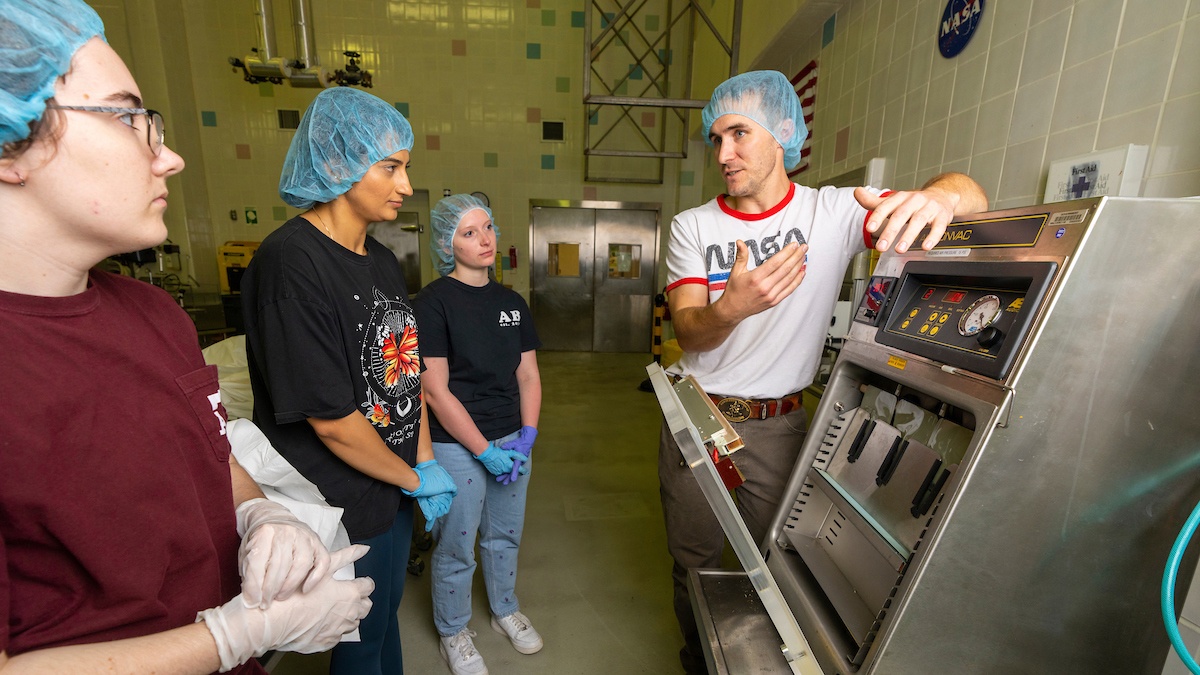 Researchers in a food science laboratory receive instructions on how to use lab equipment