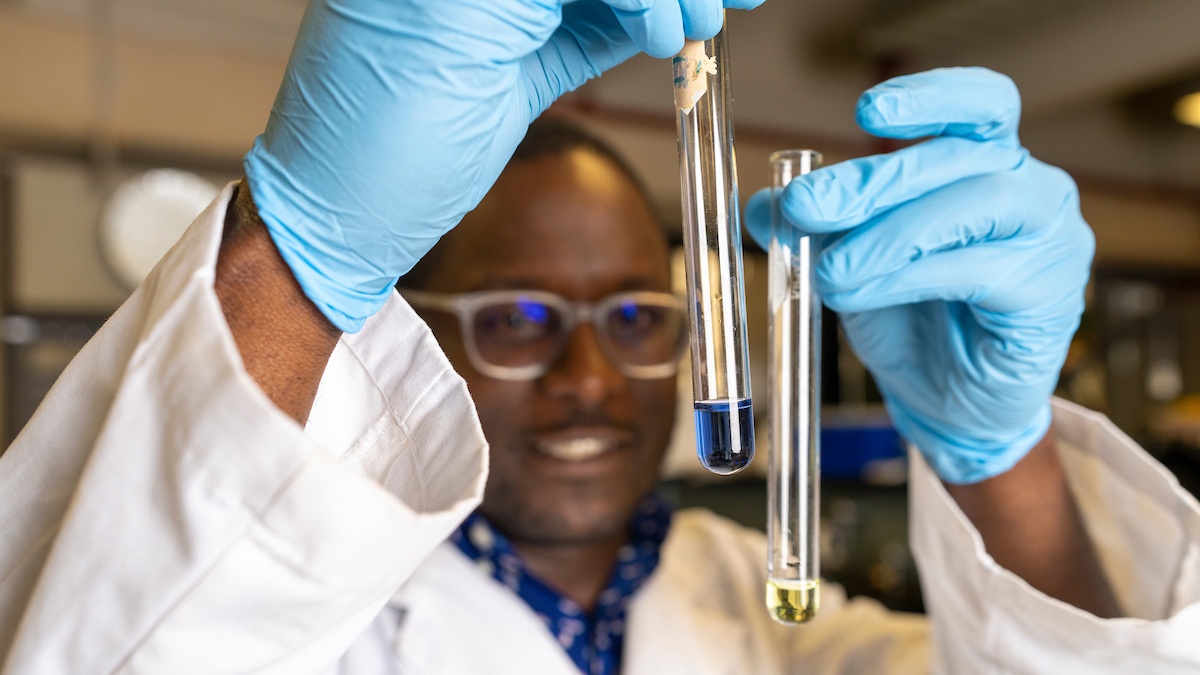 Food science researchers hold a test tube of mixed liquids in front of them
