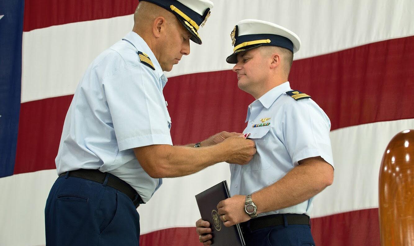 Eric Oliphant receiving an award in his Coast Guard uniform