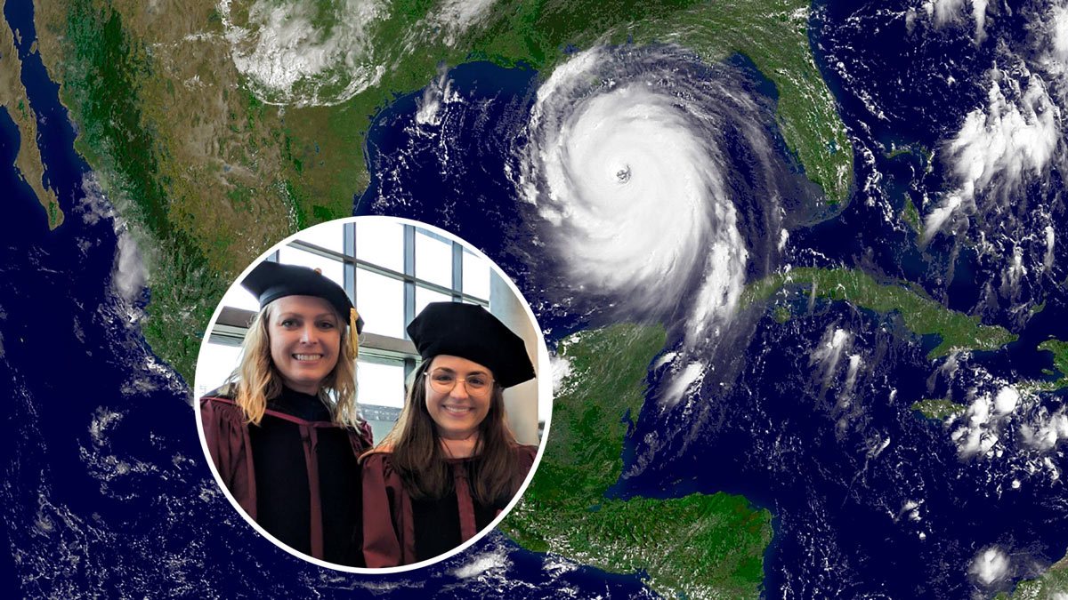 Two women in academic regalia over a radar view of a hurricane