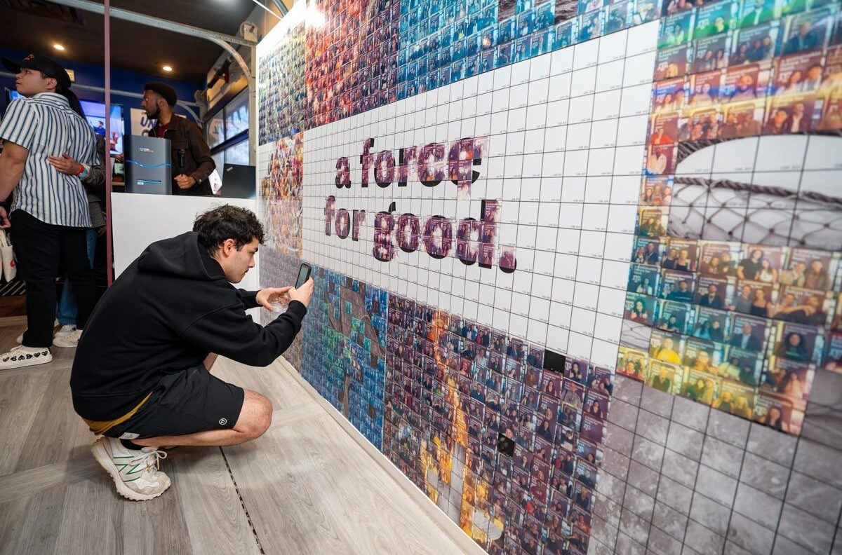 A SXSW guest takes a photo of their selfie that is part of the growing mural