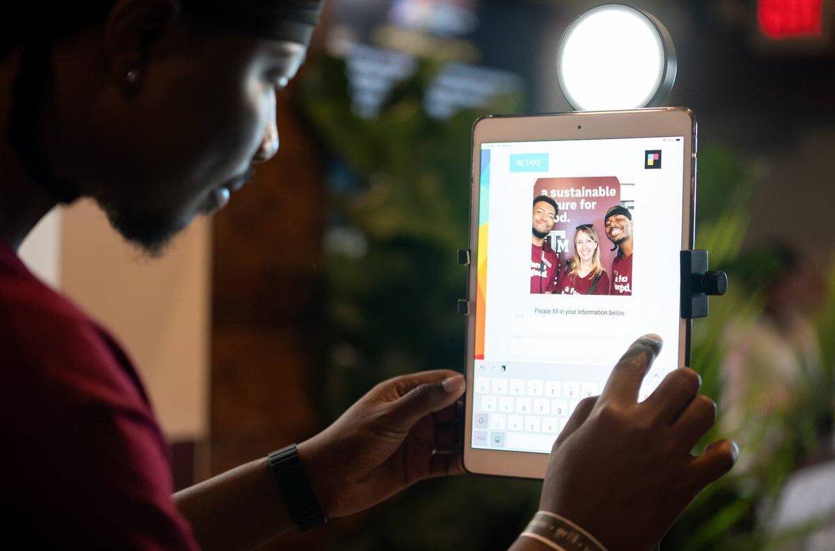 A person interacts with an iPad used to take selfies at the Texas A&M SXSW activation