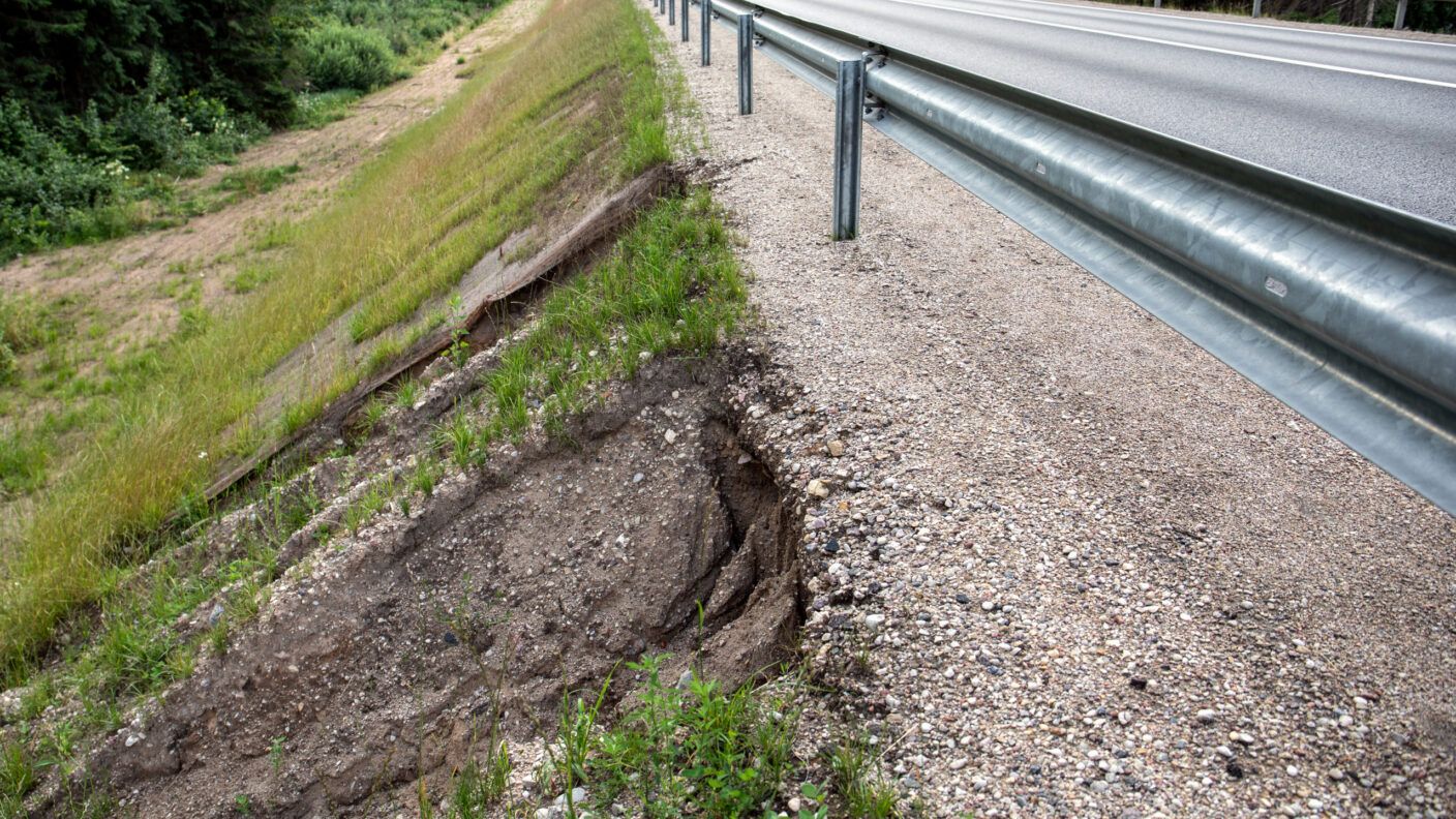 A photo of erosion on a highway embankment caused by rainwater.