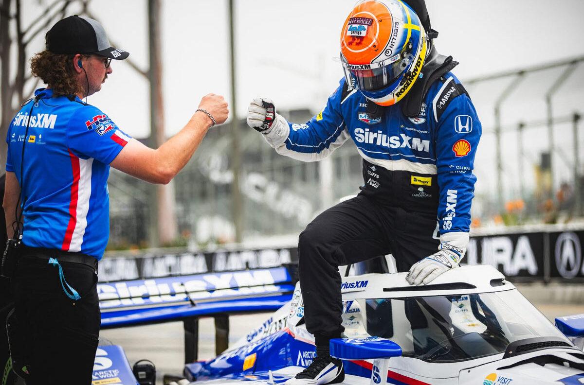 NDYCAR driver Felix Rosenqvist shares a fist bump with pit crew member