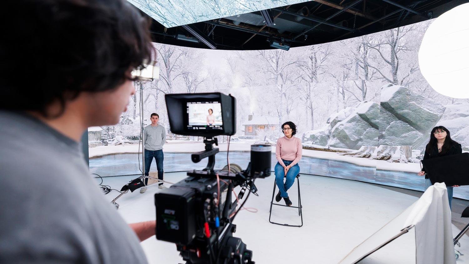View over the shoulder of a camera operator working on a virtual production sound stage