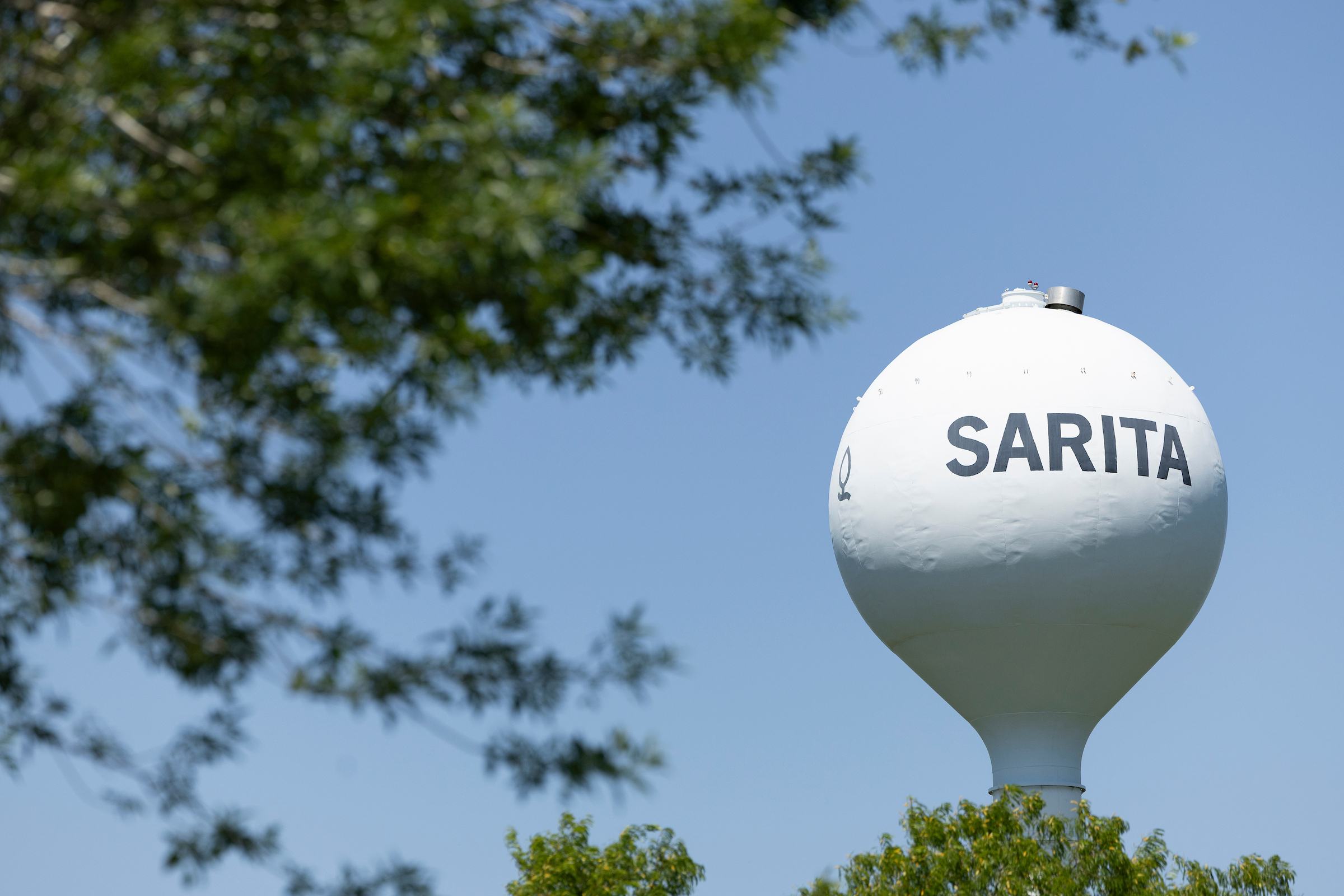 The Sarita water tower seen through the trees.